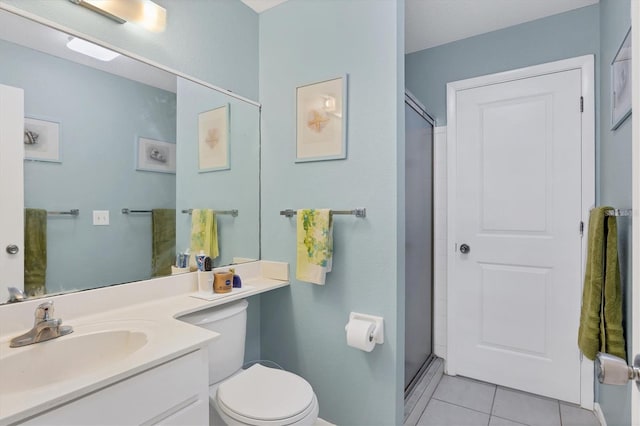 bathroom featuring tile patterned flooring, an enclosed shower, vanity, and toilet