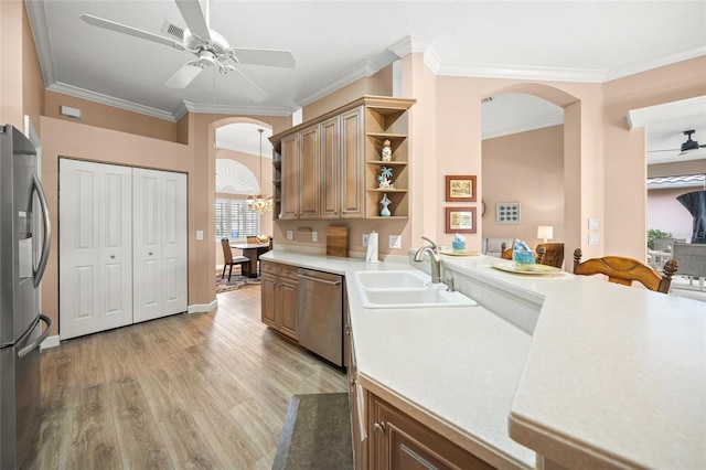 kitchen featuring crown molding, appliances with stainless steel finishes, ceiling fan with notable chandelier, and sink