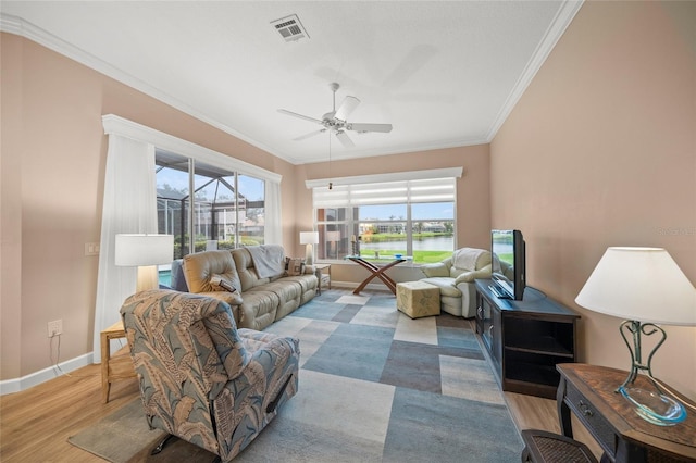 living room featuring ornamental molding, light wood-type flooring, and ceiling fan