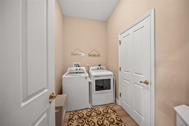 laundry room featuring light wood-type flooring and independent washer and dryer