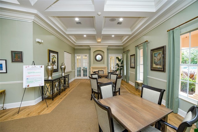 dining space with crown molding, coffered ceiling, light hardwood / wood-style floors, french doors, and beamed ceiling