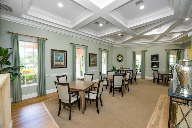 dining room with ornamental molding, coffered ceiling, beam ceiling, and light hardwood / wood-style floors