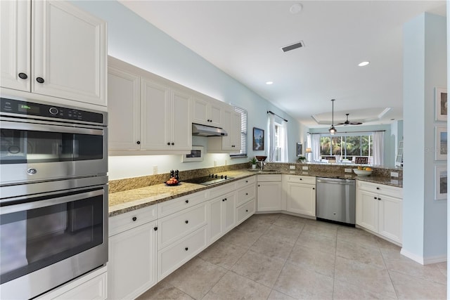 kitchen with light tile patterned floors, visible vents, appliances with stainless steel finishes, light stone counters, and under cabinet range hood