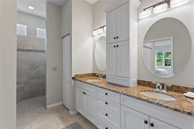 full bath with double vanity, baseboards, a walk in shower, and a sink