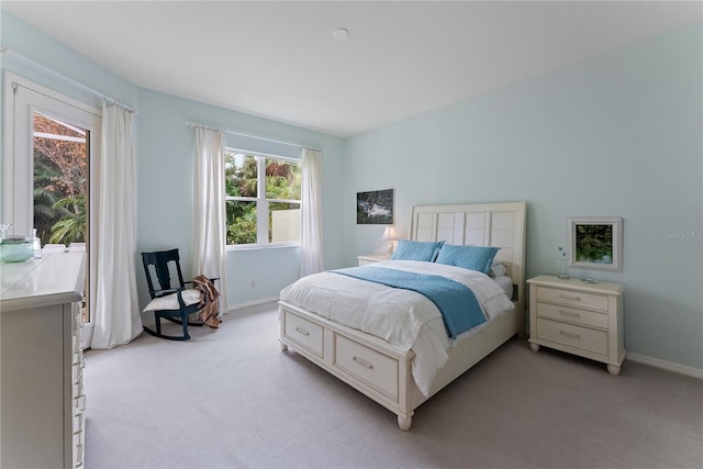 bedroom with light carpet and baseboards