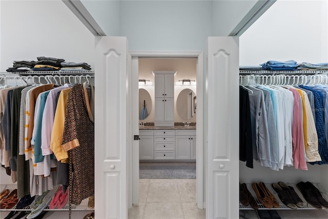 walk in closet with light tile patterned floors and a sink