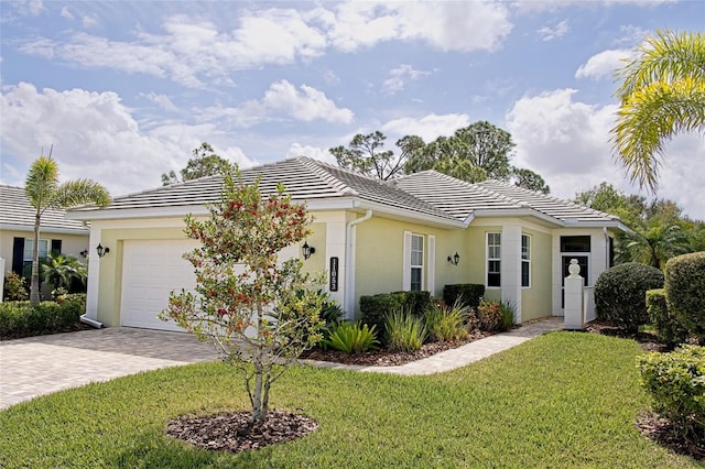 ranch-style house featuring a front yard, decorative driveway, a tiled roof, and an attached garage