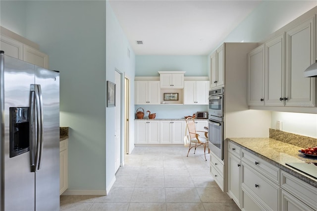 kitchen featuring baseboards, light tile patterned floors, white cabinets, visible vents, and appliances with stainless steel finishes