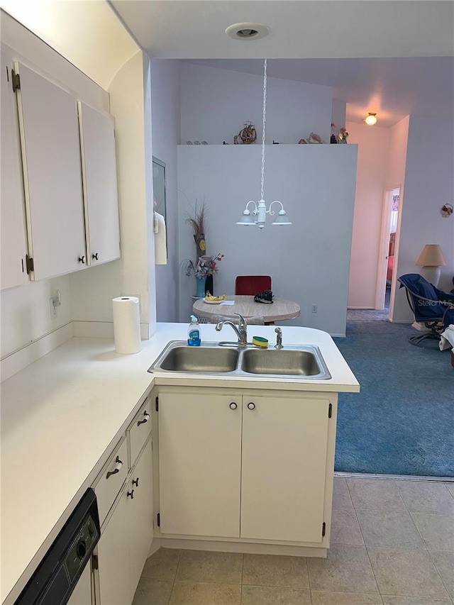 kitchen featuring sink, white dishwasher, white cabinets, decorative light fixtures, and kitchen peninsula