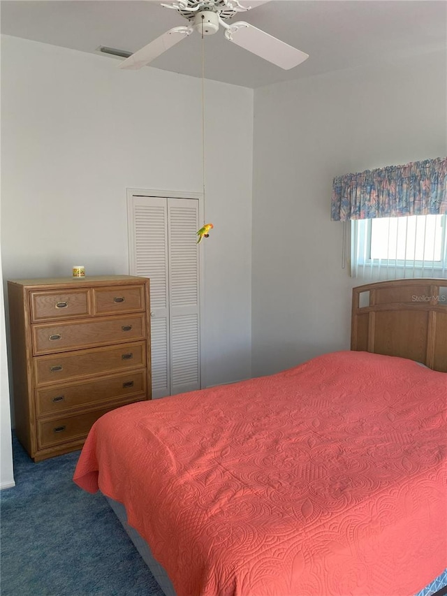 carpeted bedroom with ceiling fan and a closet