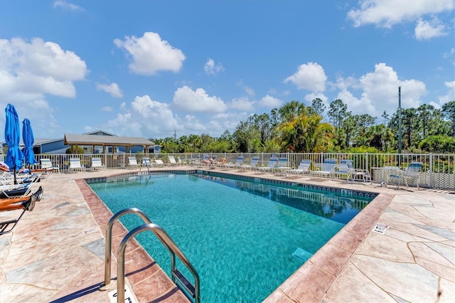 community pool featuring a patio area and fence