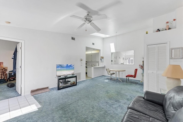 living area featuring light tile patterned floors, visible vents, a ceiling fan, and light colored carpet