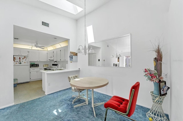 interior space with high vaulted ceiling, light carpet, a skylight, visible vents, and a wealth of natural light