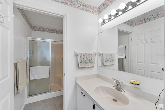 full bath with a stall shower, vanity, and tile patterned floors