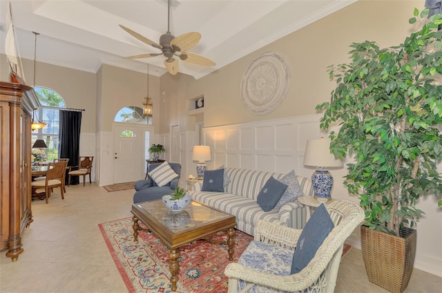 tiled living room with crown molding and ceiling fan