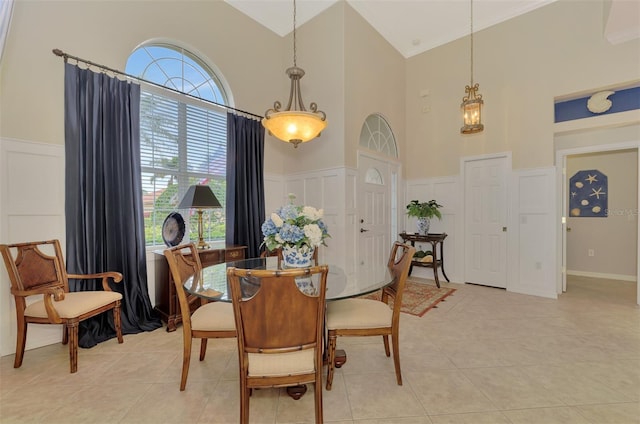 tiled dining area featuring high vaulted ceiling and ornamental molding