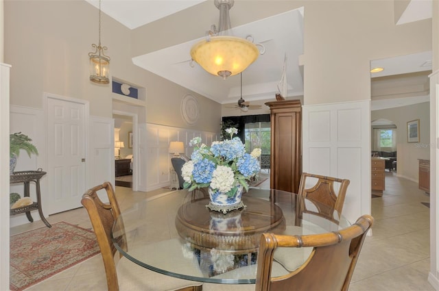 tiled dining room with plenty of natural light, high vaulted ceiling, and ceiling fan