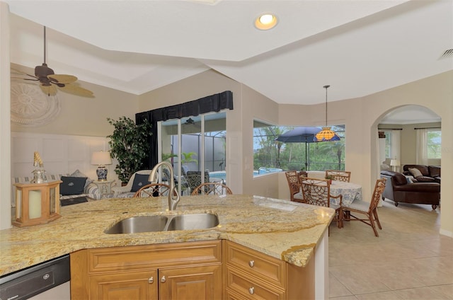 kitchen with plenty of natural light, sink, stainless steel dishwasher, and light stone counters