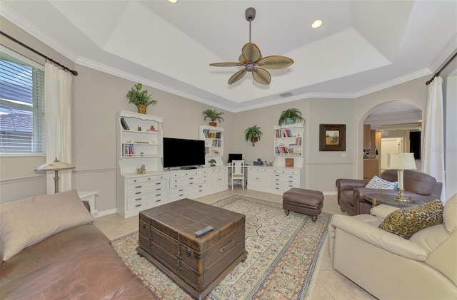 tiled living room featuring crown molding, ceiling fan, and a tray ceiling