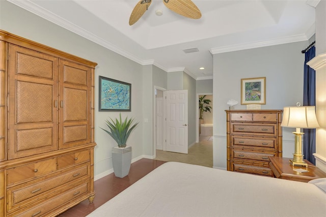 bedroom featuring dark wood-type flooring, ensuite bathroom, crown molding, a raised ceiling, and ceiling fan