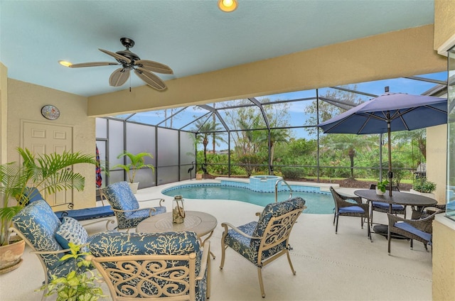 view of swimming pool with a patio area, ceiling fan, and glass enclosure