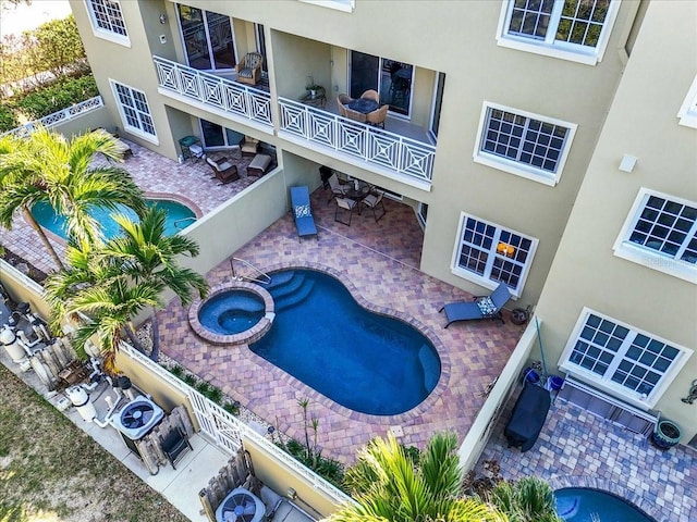 view of swimming pool featuring a patio and an in ground hot tub