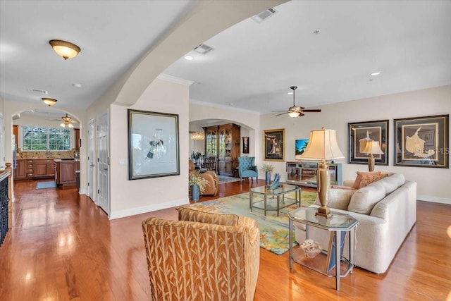 living room featuring ornamental molding, hardwood / wood-style floors, and ceiling fan