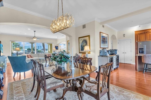 dining area with light hardwood / wood-style flooring, ornamental molding, and ceiling fan