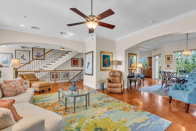 living room with ornamental molding, a chandelier, and hardwood / wood-style floors