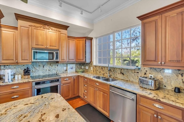 kitchen featuring light stone counters, appliances with stainless steel finishes, sink, and tasteful backsplash