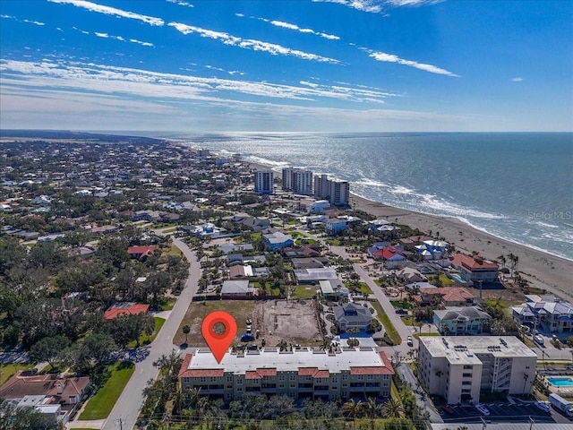 birds eye view of property with a water view and a beach view