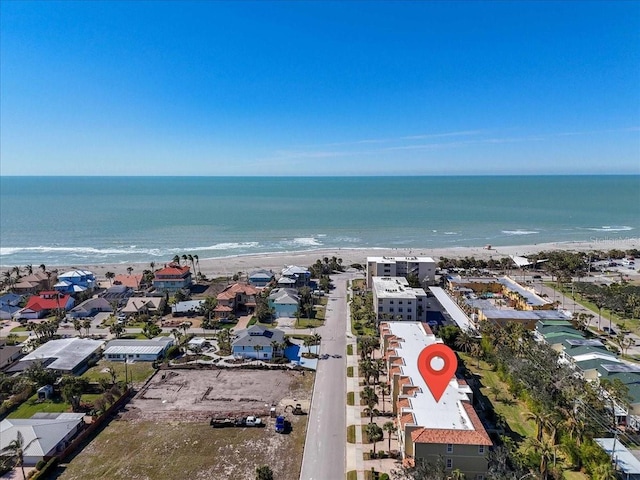 drone / aerial view featuring a beach view and a water view