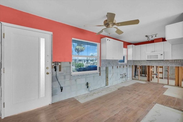 kitchen featuring track lighting, white cabinets, and ceiling fan