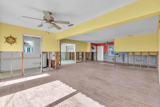 unfurnished room featuring ceiling fan and gas water heater