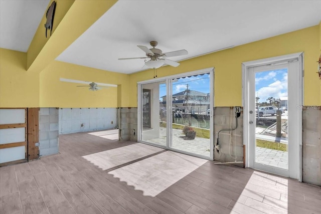 doorway to outside with ceiling fan and a water view