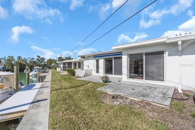 back of house featuring a lawn and a water view