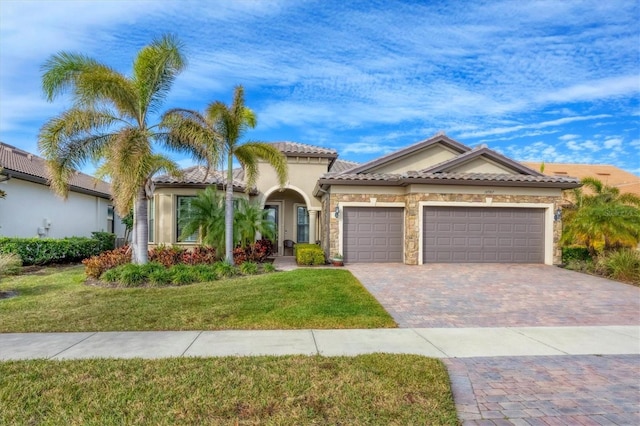 mediterranean / spanish-style home featuring a garage and a front yard