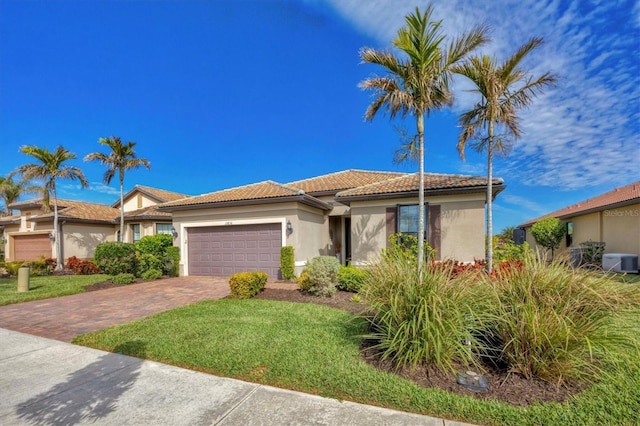 view of front of house featuring a garage, central AC unit, and a front lawn