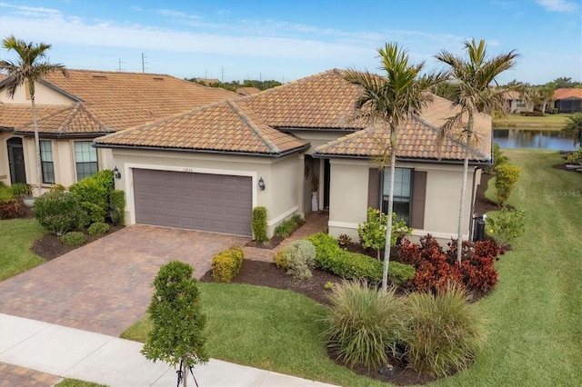 view of front of home featuring a garage, a front yard, and a water view