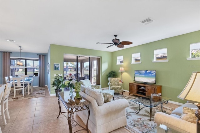 tiled living room featuring a wealth of natural light and ceiling fan