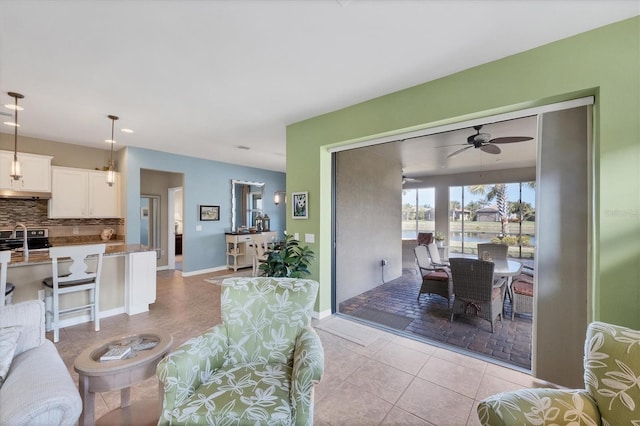 tiled living room featuring sink and ceiling fan