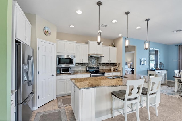 kitchen featuring white cabinetry, appliances with stainless steel finishes, sink, and a center island with sink