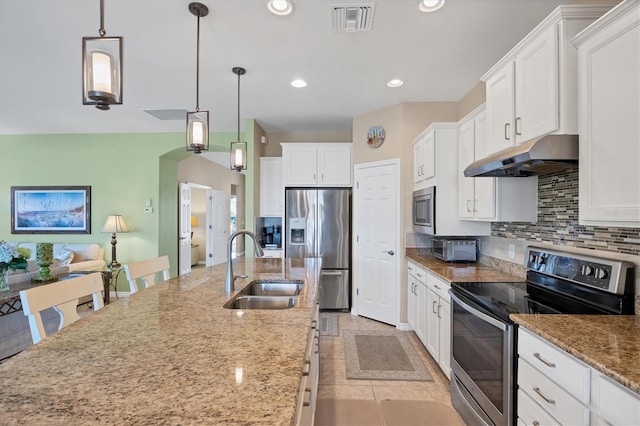 kitchen with stainless steel appliances, stone countertops, sink, and decorative light fixtures