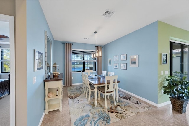 tiled dining space featuring a notable chandelier