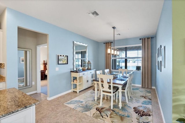 dining space with a chandelier and light tile patterned floors