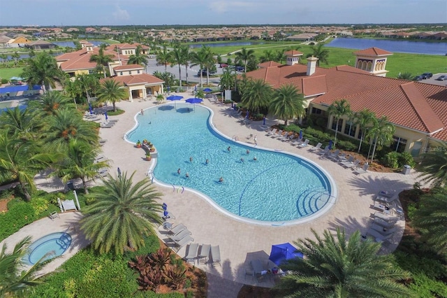 view of swimming pool with a patio area and a water view