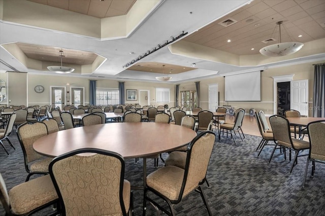 carpeted dining space featuring a tray ceiling