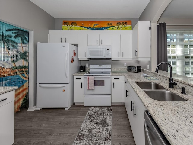 kitchen featuring white cabinetry, sink, light stone counters, dark wood-type flooring, and white appliances