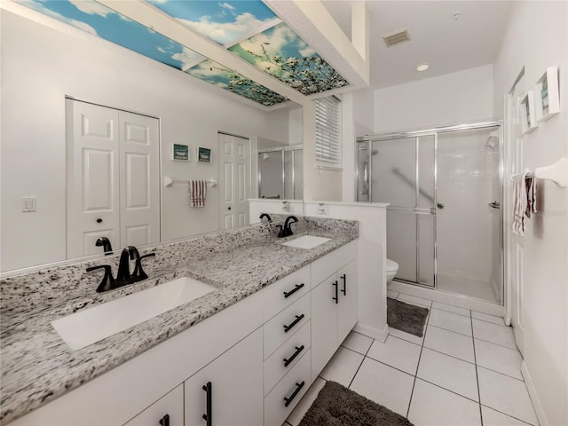 bathroom with tile patterned flooring, vanity, toilet, and a shower with shower door