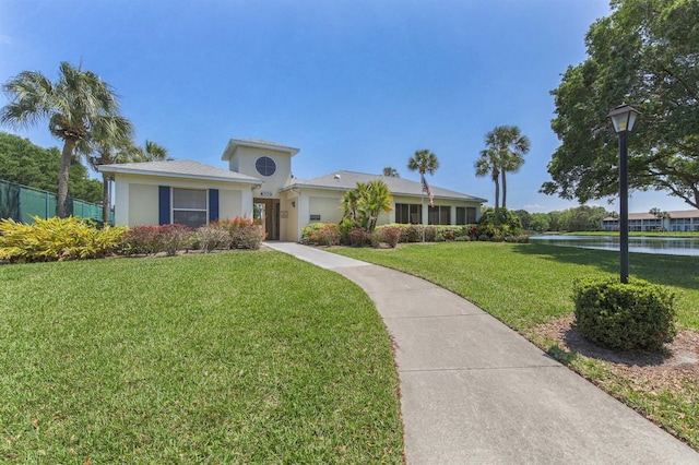 view of front facade with a water view and a front lawn